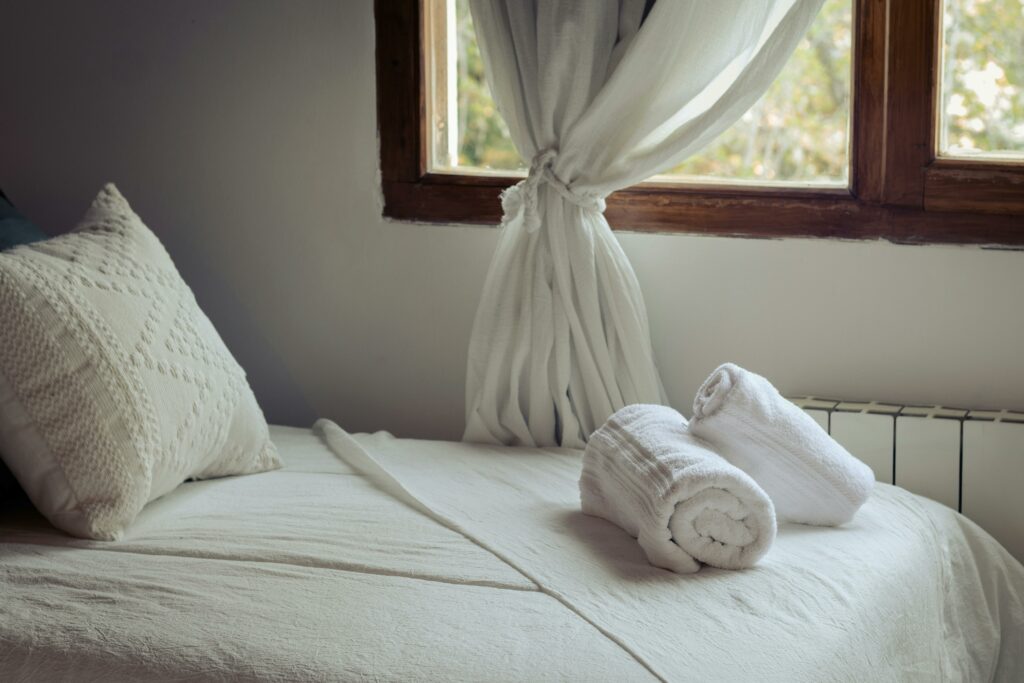 Lit préparé avec serviettes pliées dans une location courte durée